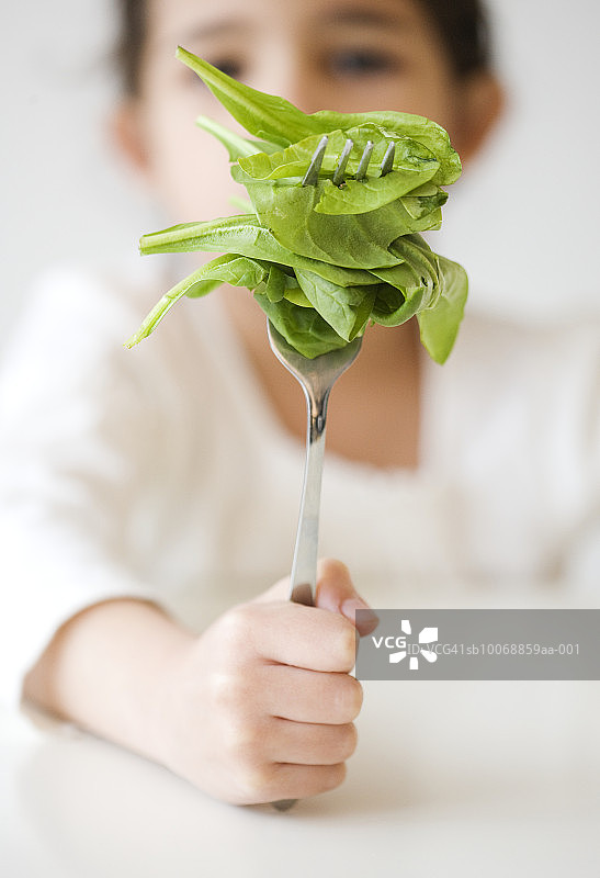 儿童手拿带菜叶的叉子特写图片素材