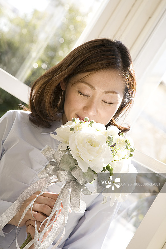 女人闻白色玫瑰花束图片素材