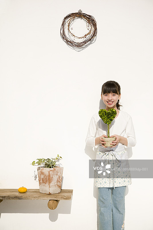 手捧心形盆栽的女孩肖像（10-11岁）图片素材