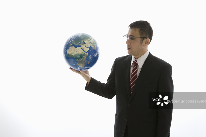 商人手持地球仪拍摄图片素材