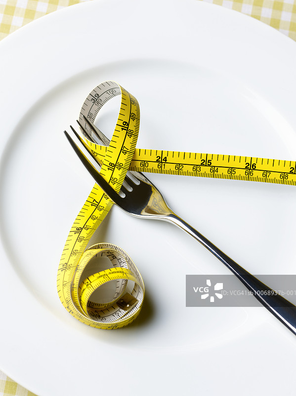 餐盘上的叉子和卷尺特写图片素材
