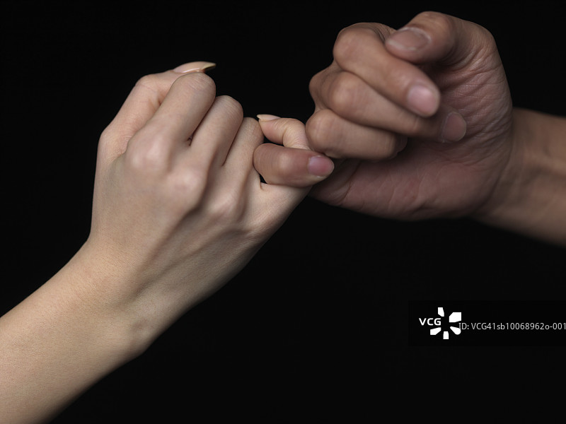 男人和女人拉钩，手部特写图片素材