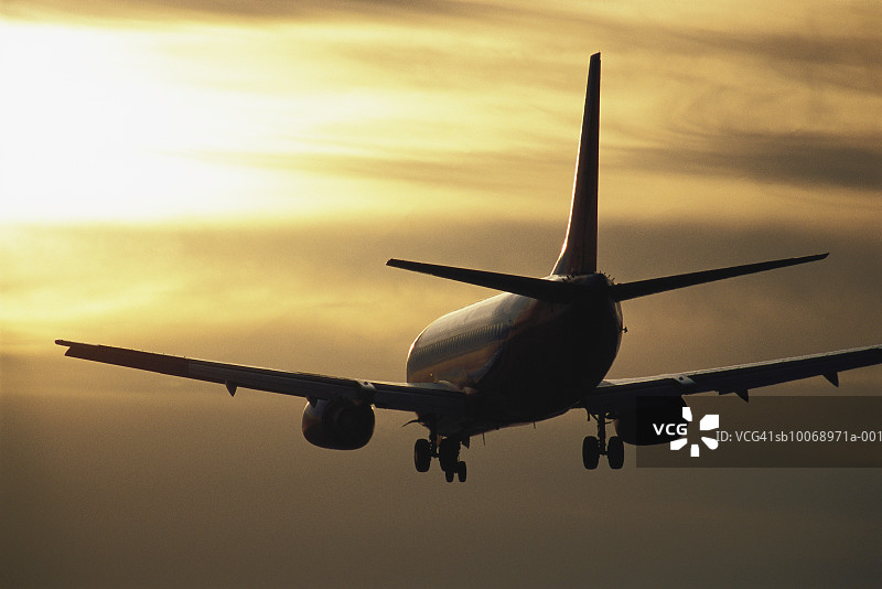 日落时分飞行中的商用飞机图片素材