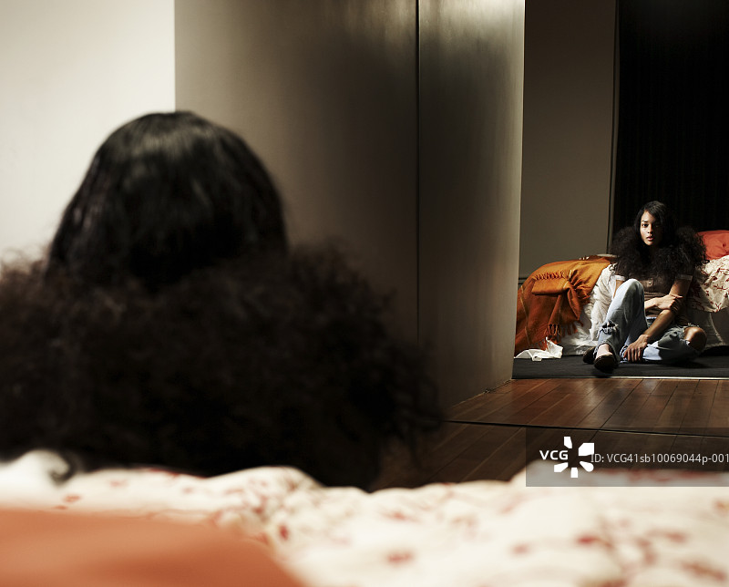 年轻女人坐在卧室的镜子前图片素材