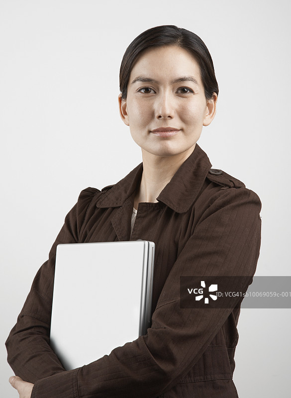 手持笔记本电脑的女性棚拍肖像图片素材