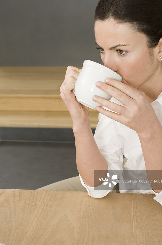 女人用杯子喝水图片素材