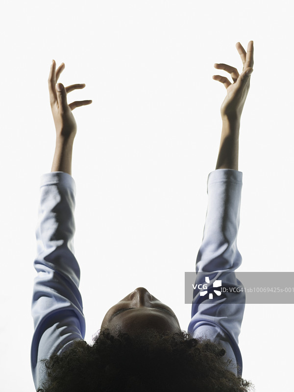 年轻女人向上伸出手，影棚拍摄图片素材