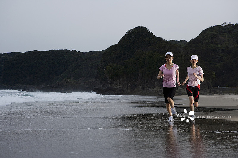 两名女子在海滩上慢跑图片素材