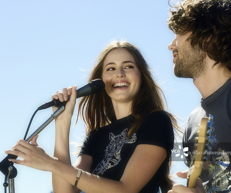 年轻女子唱歌，男子弹吉他图片素材