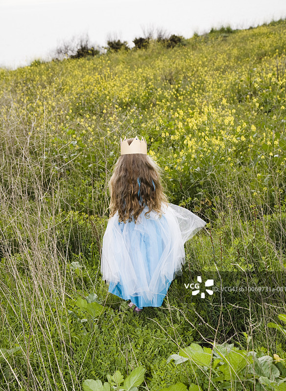 戴着皇冠在田野里行走的女孩（4-5岁）图片素材