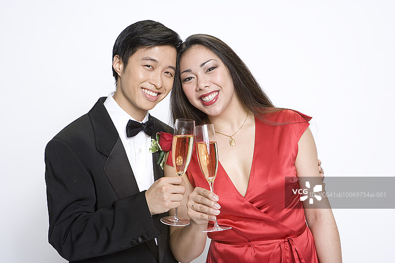 穿着讲究的夫妇敬香槟，工作室肖像图片素材