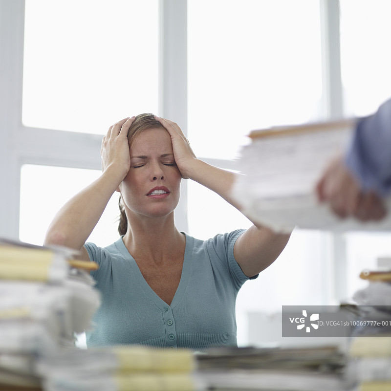 坐在桌前双手抱头闭眼的女人图片素材