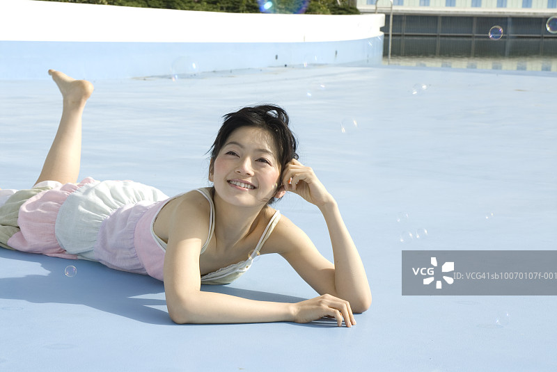 微笑地看着泡泡的年轻女子图片素材