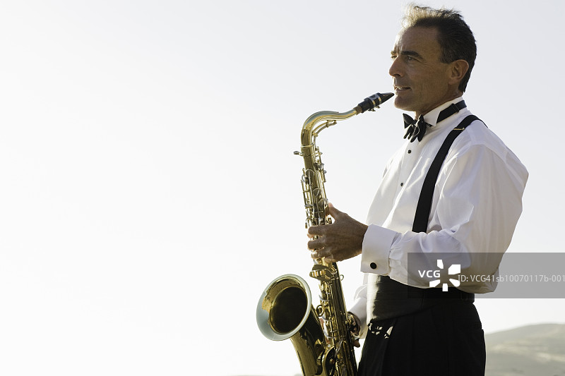 在晴空下吹萨克斯的年长男人图片素材