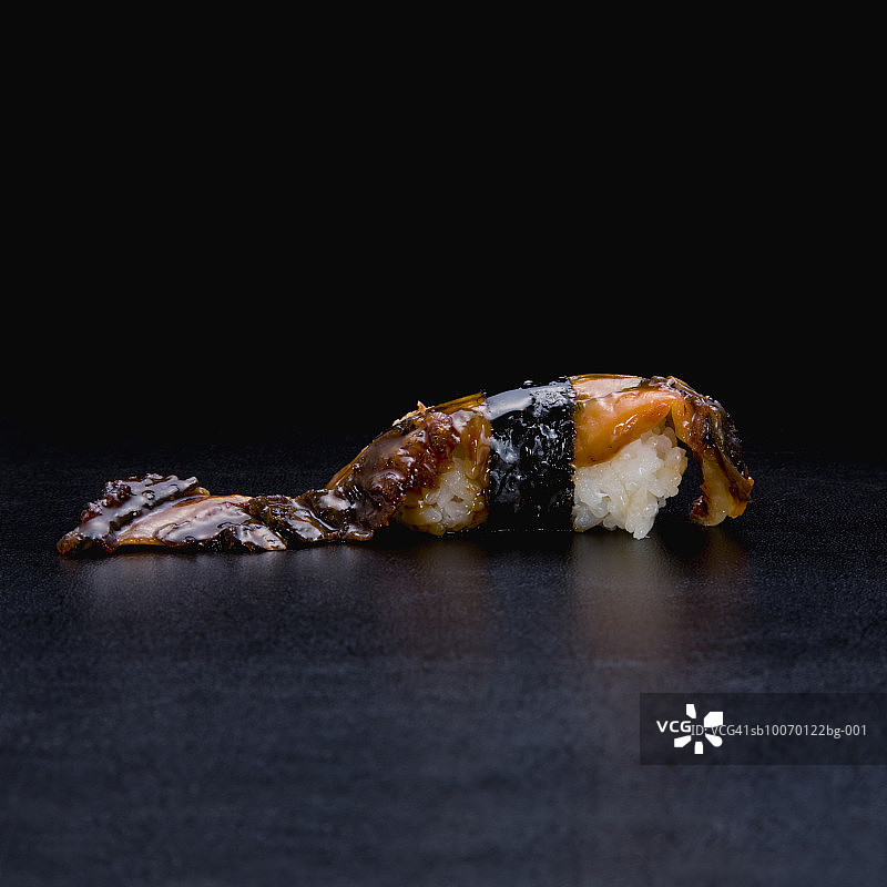黑色背景上的鳗鱼寿司图片素材