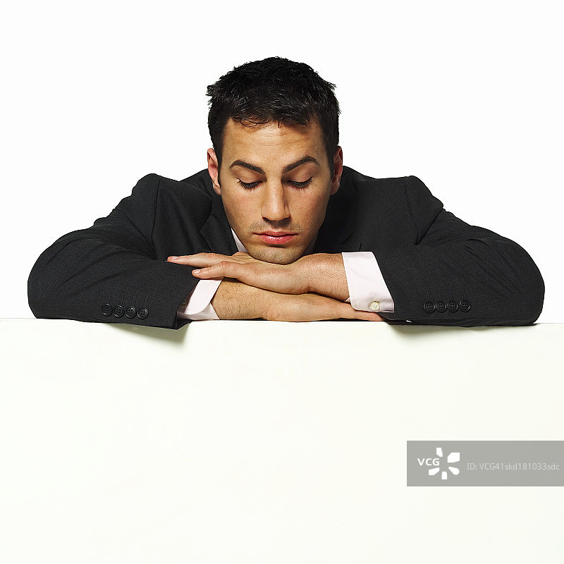 年轻商人倚靠隔板特写图片素材