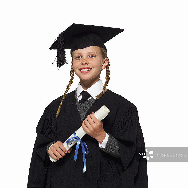 戴着帽子和学位服的女孩（10-12岁）的肖像图片素材