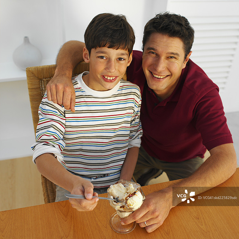 父亲和儿子（11-12岁）拿着冰淇淋 elevated view图片素材
