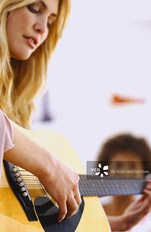 弹奏原声吉他的年轻女子特写图片素材