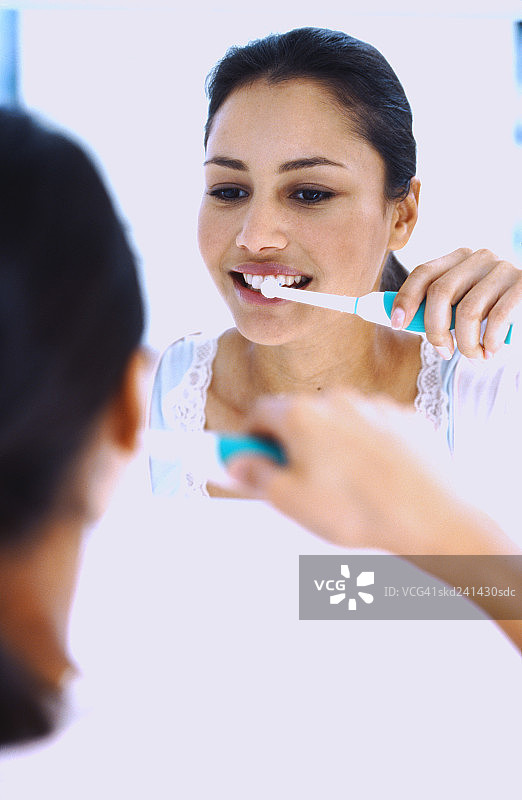 女人用电动牙刷刷牙图片素材