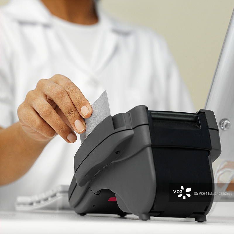 牙科护士使用信用卡读卡器处理付款图片素材