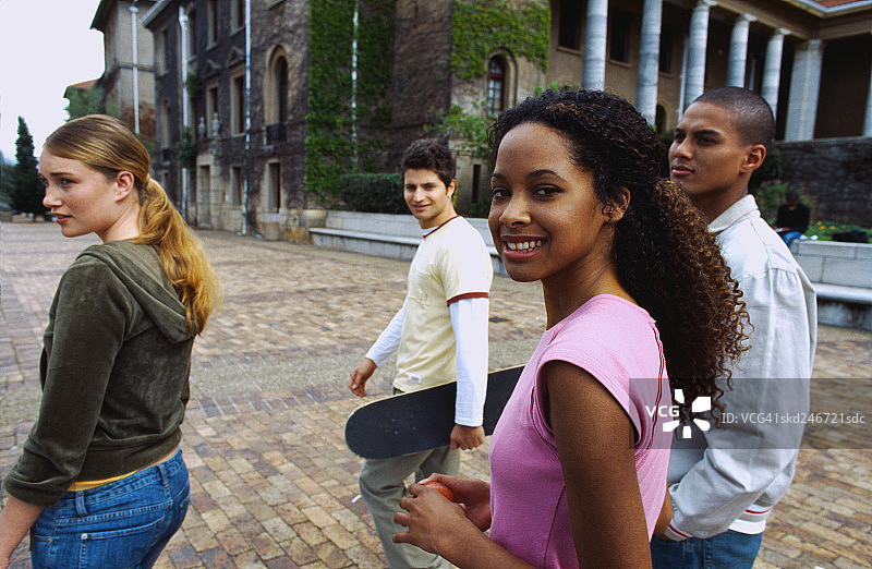 一群年轻学生在户外行走的侧面照图片素材