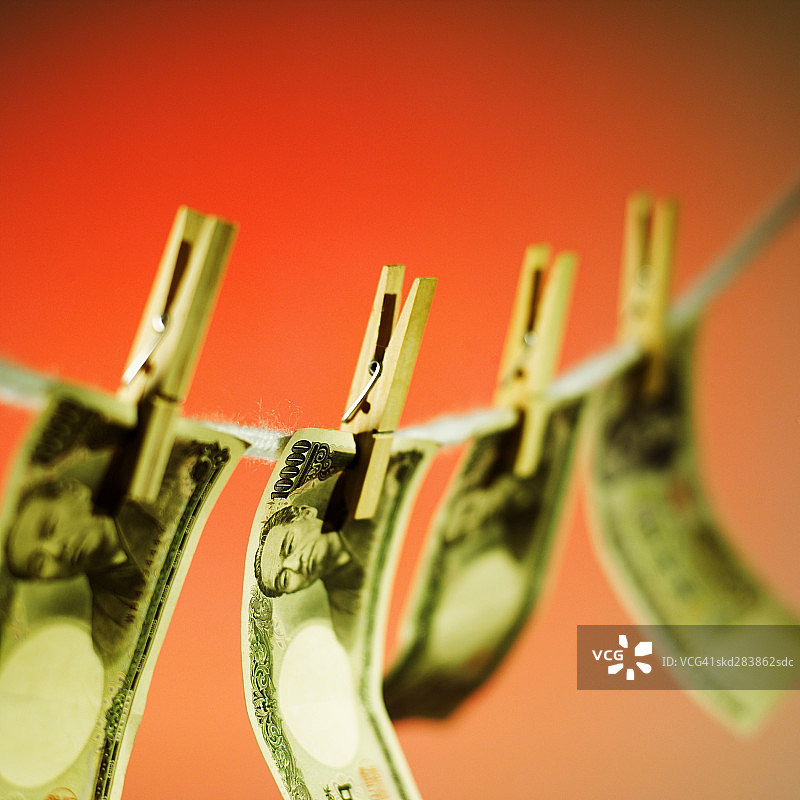 挂在晾衣绳上的日元纸币特写图片素材