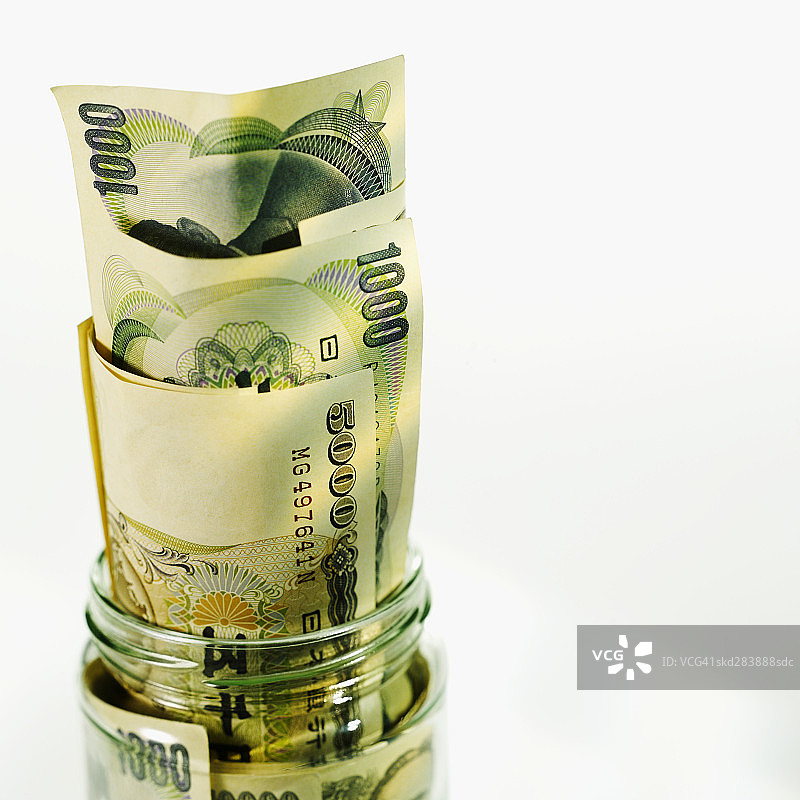装满日元纸币的罐子特写图片素材