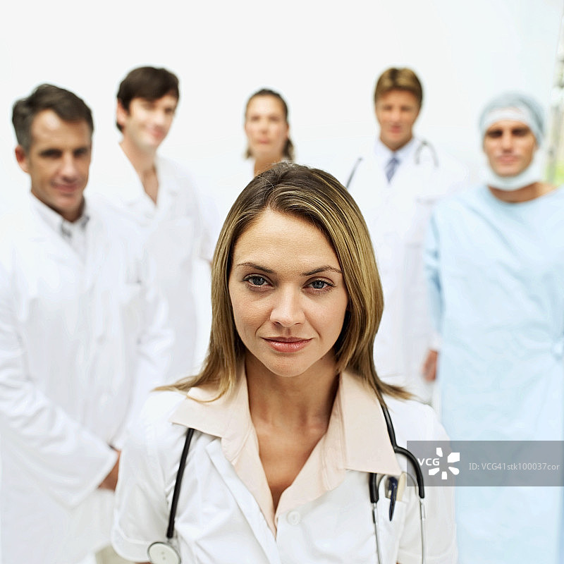 女医生站在一群医生前的肖像图片素材