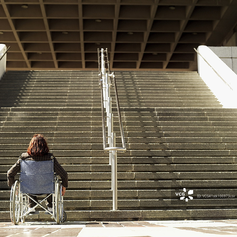 面对台阶的轮椅使用者的背面视角图片素材