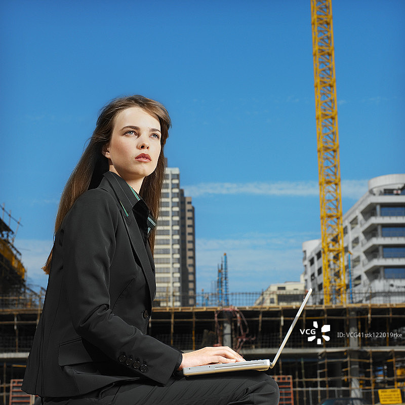 年轻女人操作笔记本电脑的侧面轮廓照片图片素材