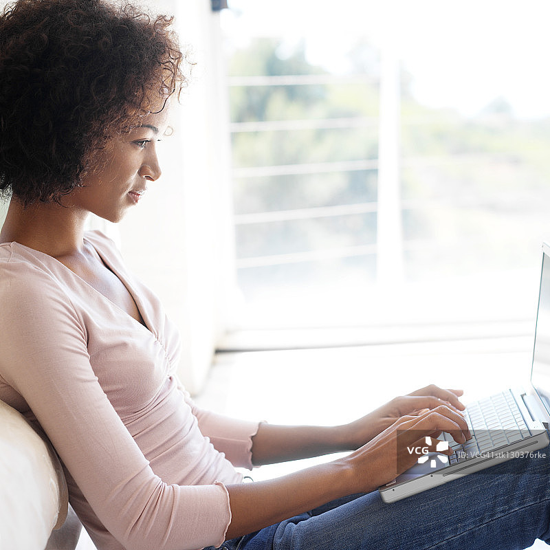 用笔记本电脑工作的年轻女人侧面轮廓图片素材