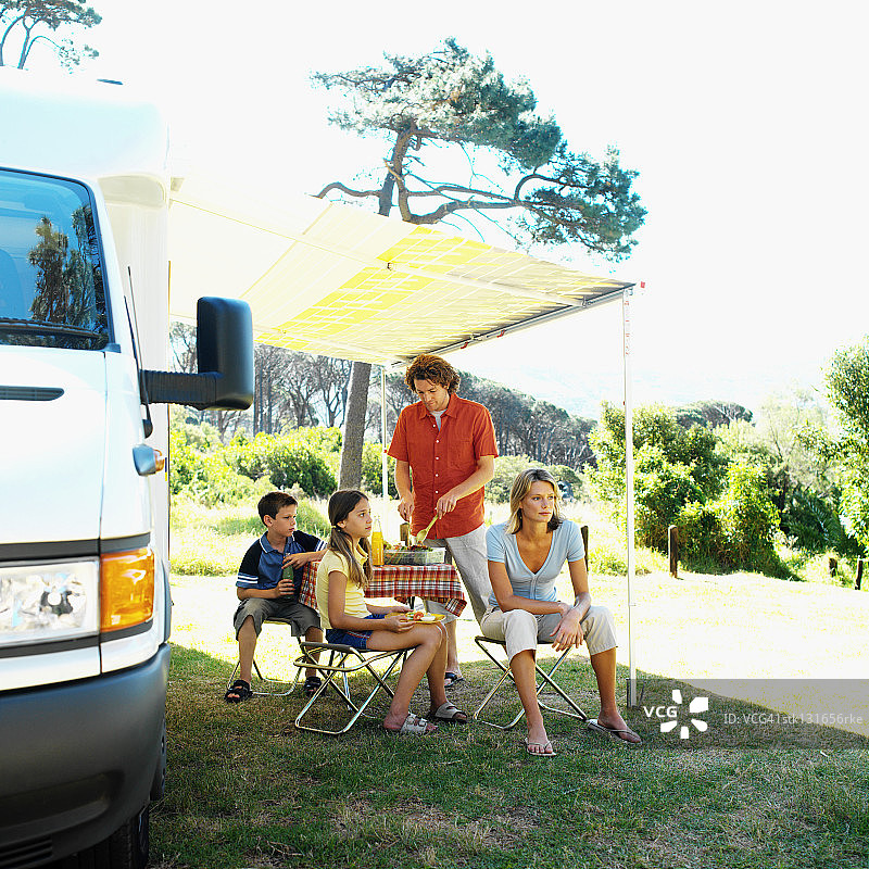 母亲和父亲准备食物，儿子和女儿在乡下度假图片素材