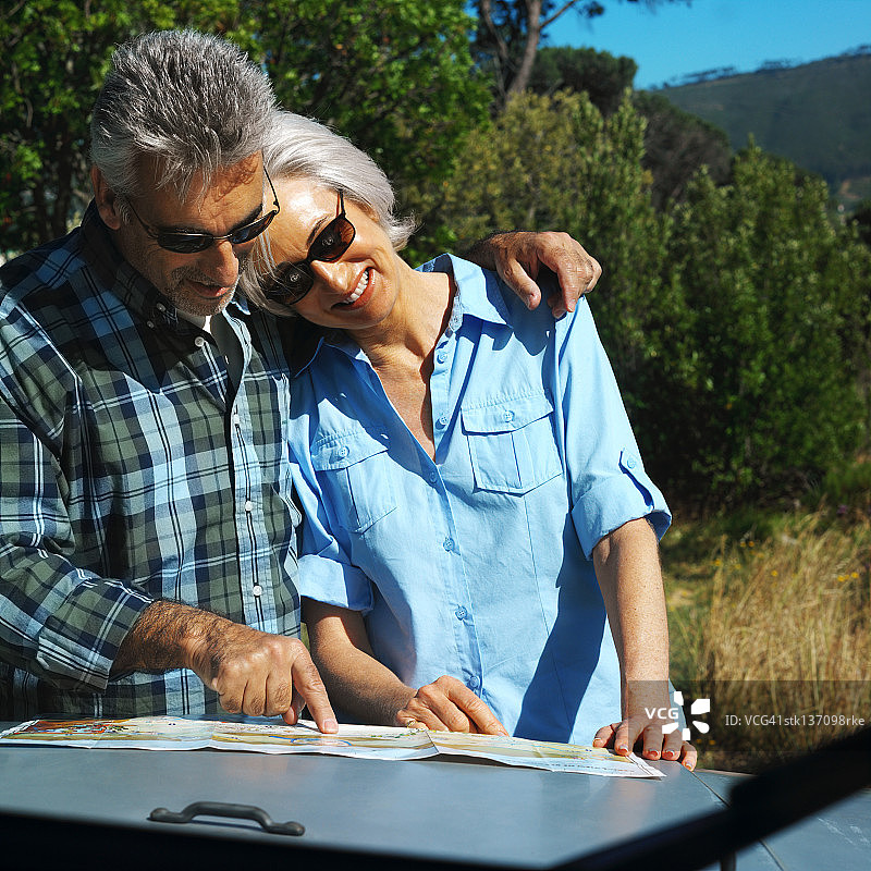 中年夫妇站在一起看地图图片素材