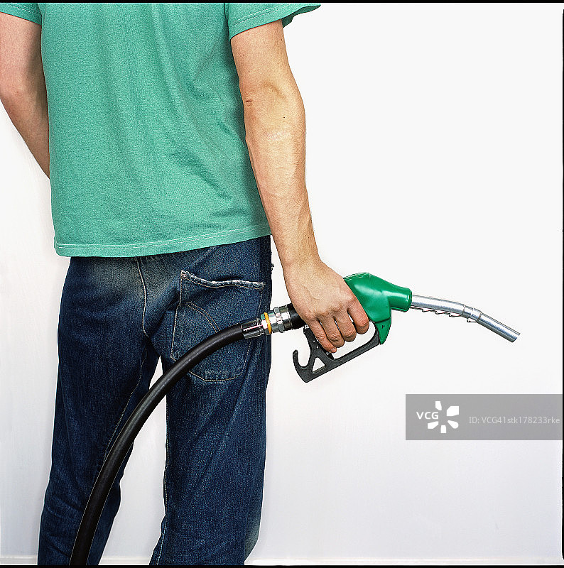 男人拿着汽油泵喷嘴的背影图片素材