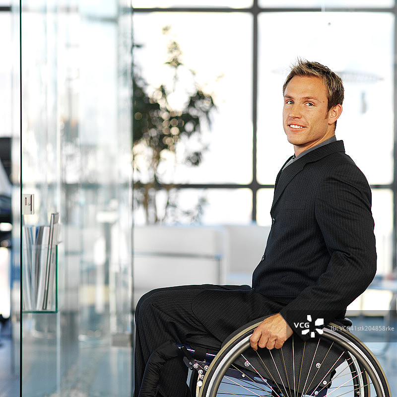 坐在办公室轮椅上的商人肖像图片素材