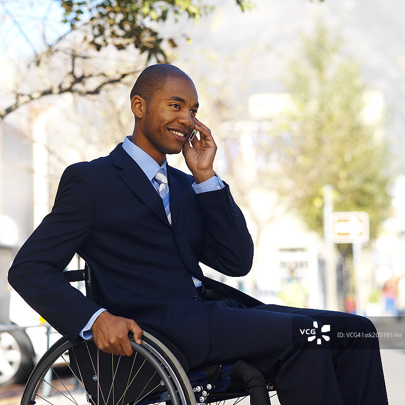坐在轮椅上用手机交谈的商人图片素材
