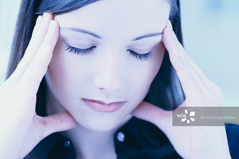 特写：闭眼按太阳穴的女人图片素材