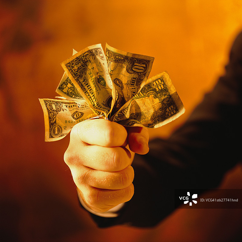 男子紧握美元的拳头特写图片素材