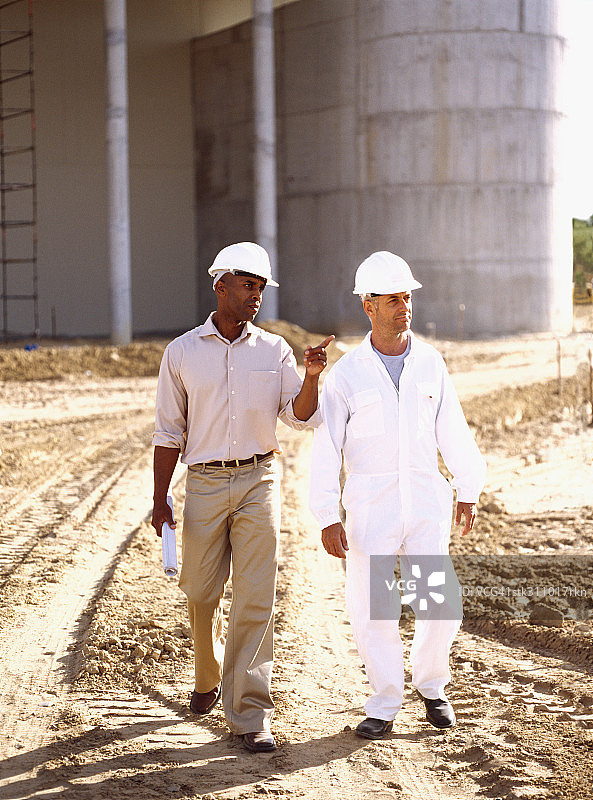 建筑师在建筑工地与建筑工人交谈图片素材
