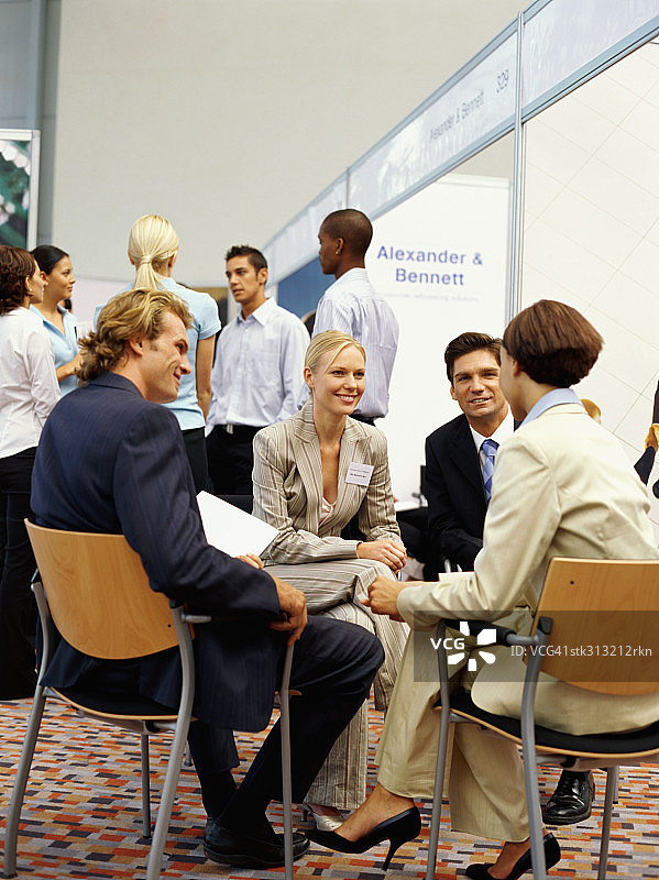 四位商务人士在展览会上讨论图片素材