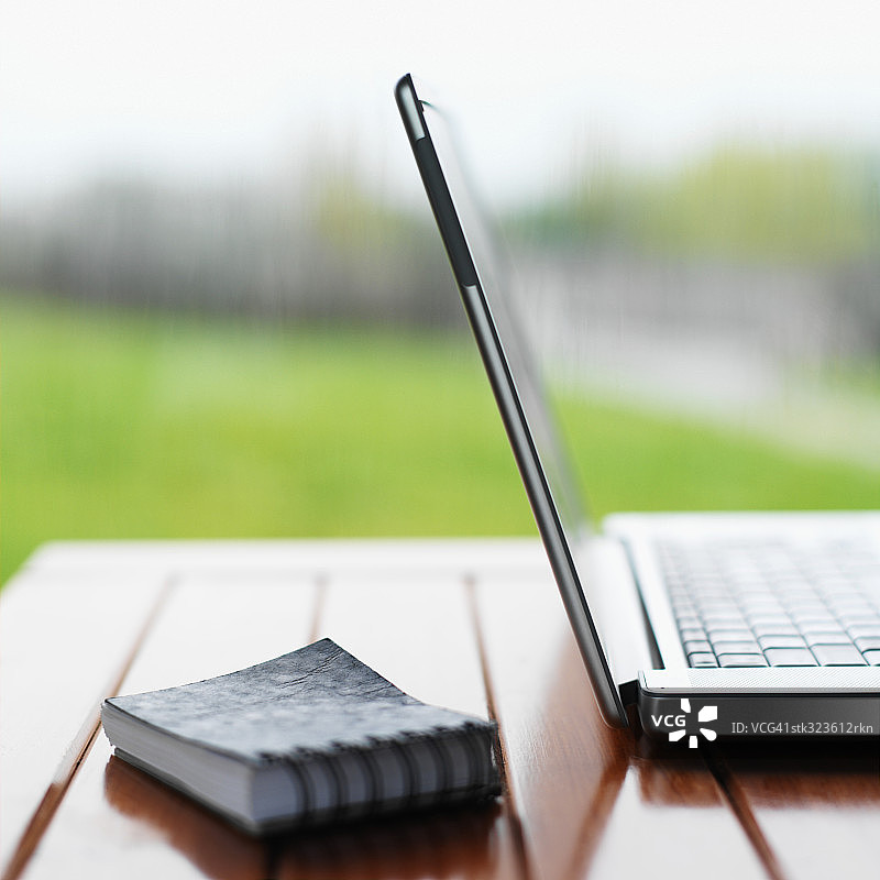 笔记本电脑和螺旋笔记本特写图片素材