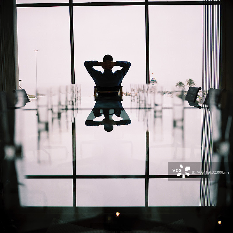 商务人士在会议桌旁放松身心图片素材