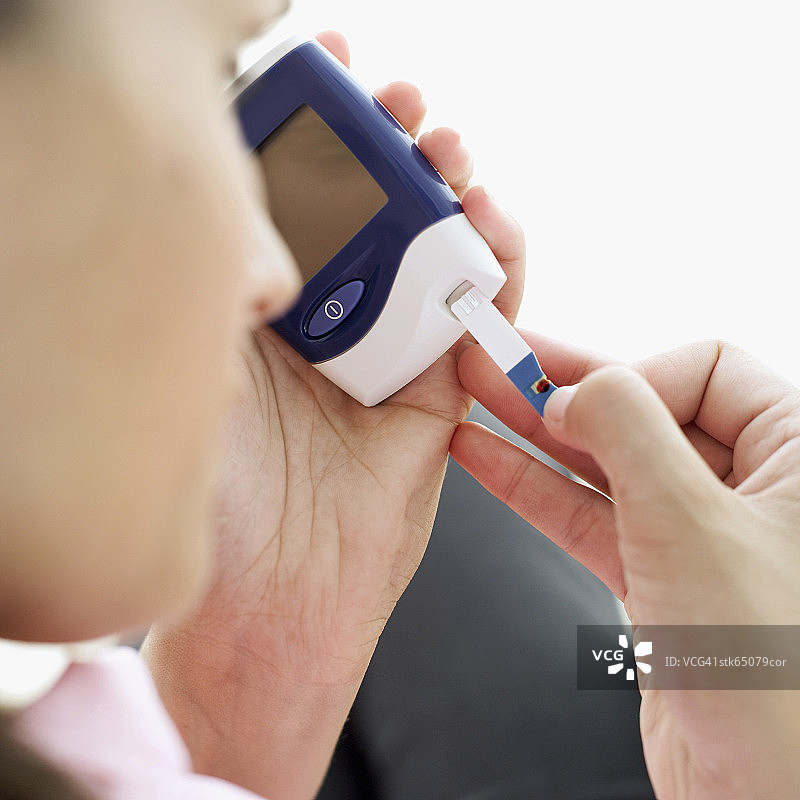 使用手持血糖仪的人图片素材