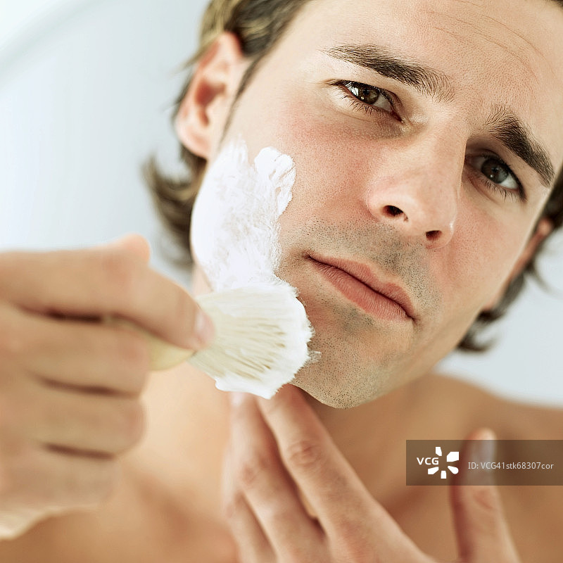 男人用刷子涂抹剃须膏特写图片素材