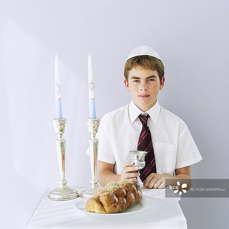 手持Challah面包和Kiddush杯的犹太男孩(11-13岁) портрет图片素材