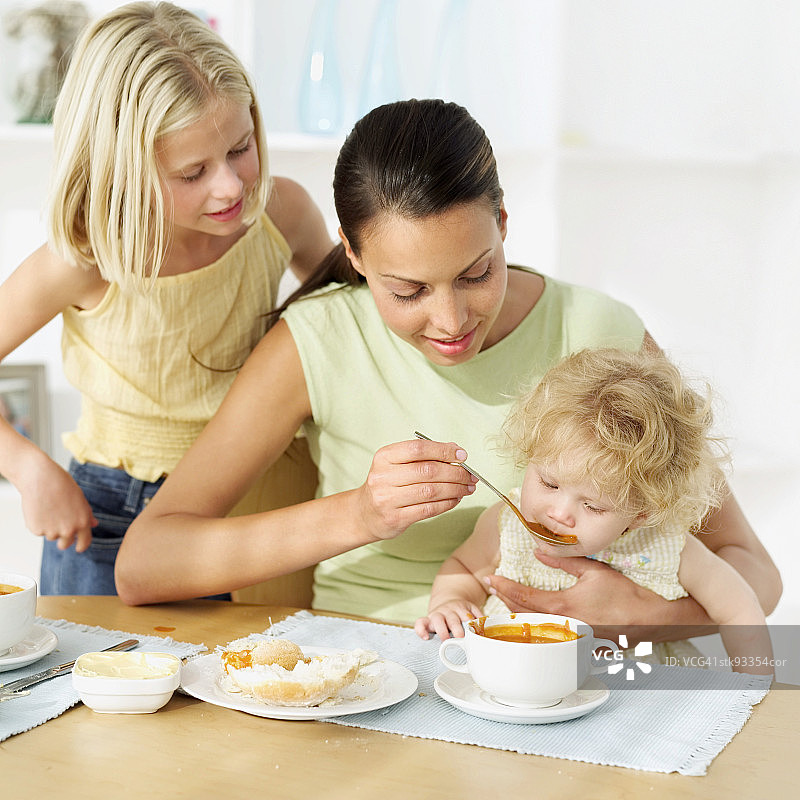 母亲喂女儿喝汤图片素材