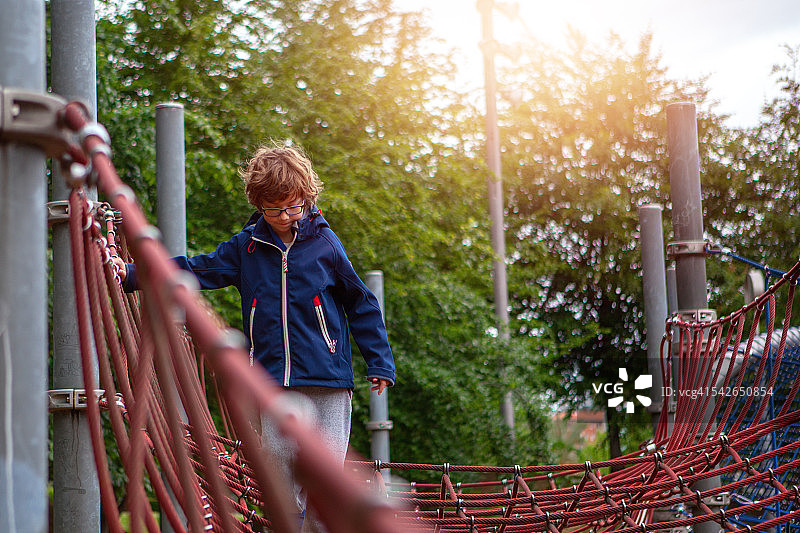男孩在攀爬儿童乐园的攀爬架图片素材