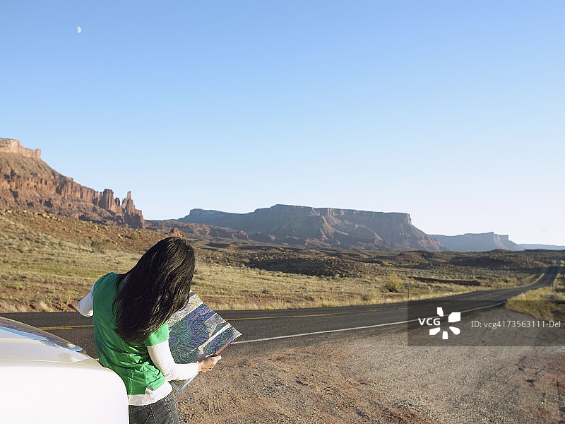 在犹他州摩押沙漠中看地图的女人图片素材