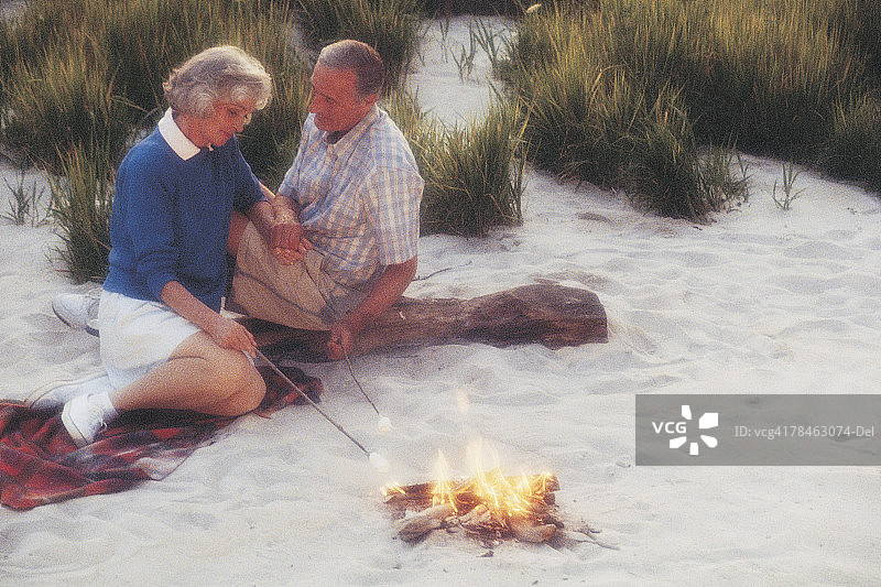 中年夫妇在海滩上生篝火图片素材